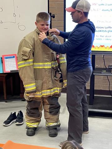 Fourth Grade Student Trying on Fire Fighter Gear